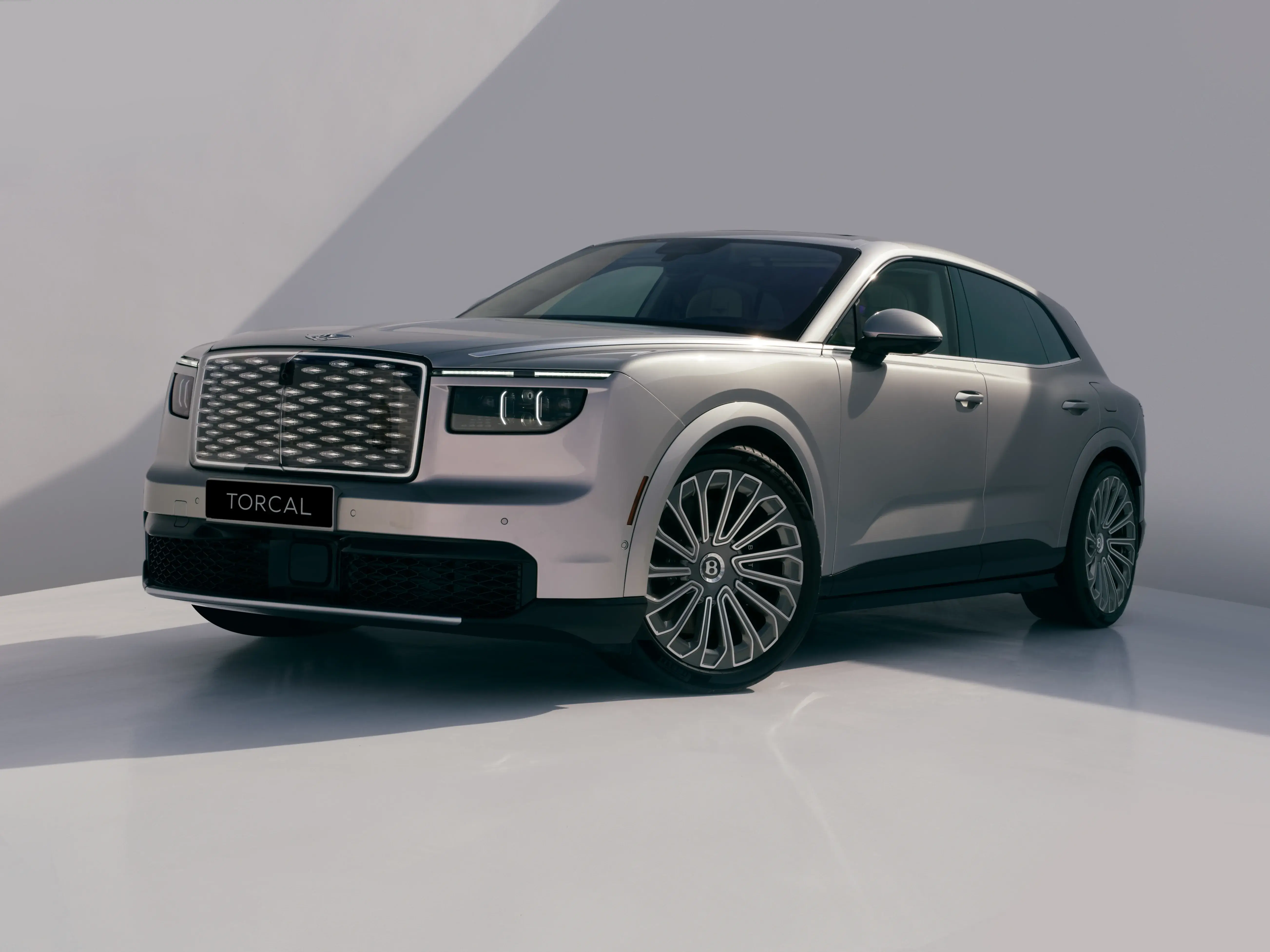 Front three-quarter view of a silver Bentley Torcal showing its illuminated diamond grille and large wheels